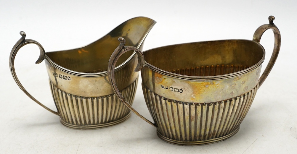 A late Victorian demi-fluted sugar bowl and cream jug, by Mappin & Webb, Sheffield, 1894, 8.6oz. Condition - fair